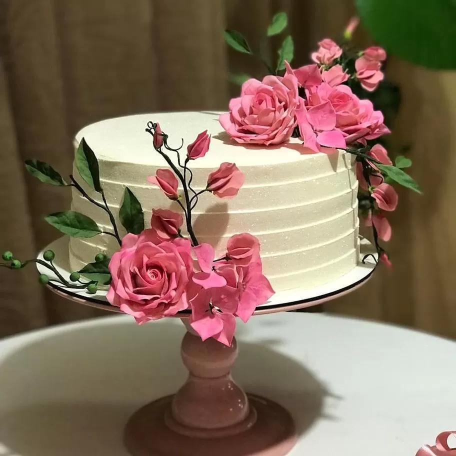 Feminino mão decorando o bolo de aniversário de casamento flor