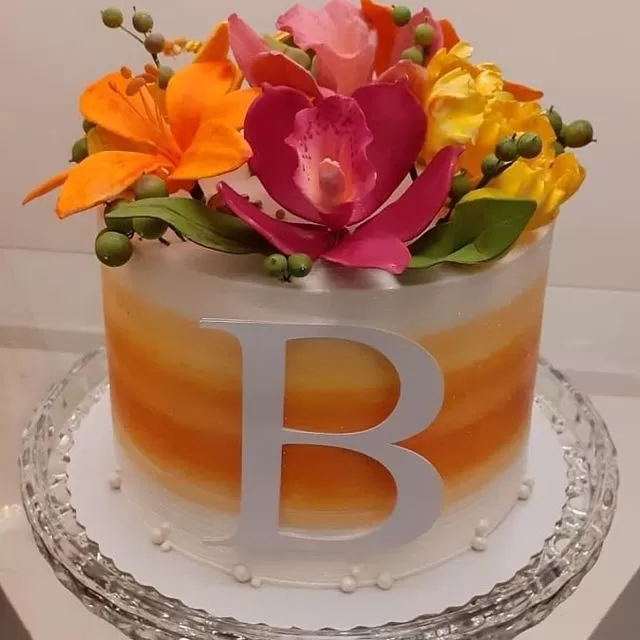 Feminino mão decorando o bolo de aniversário de casamento flor