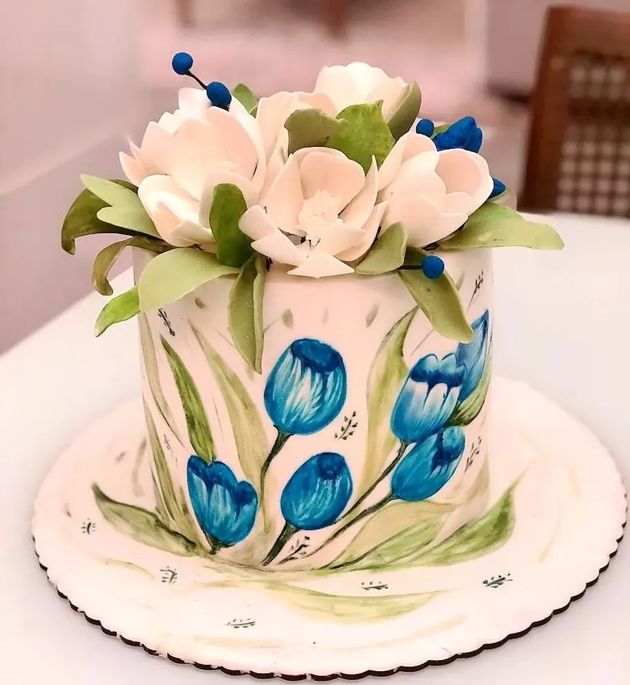 Feminino mão decorando o bolo de aniversário de casamento flor rosa no  carrinho.